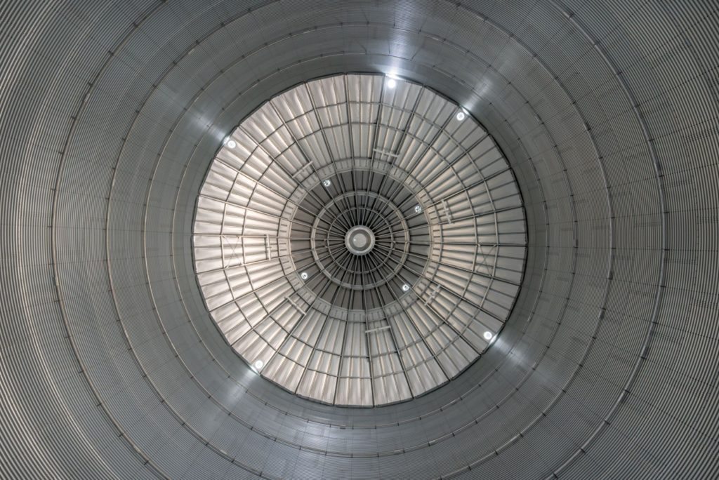 Blick auf die gewölbte Decke eines großen, modernen Industriegebäudes mit gleichmäßiger Beleuchtung.