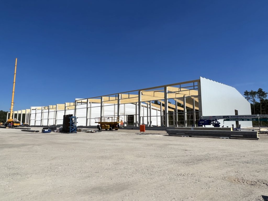 Neubau eines großen Gebäudes mit Holzrahmen und blauen Himmel im Hintergrund.