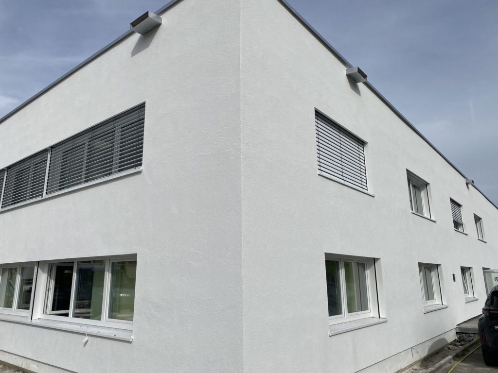 Fassade des sanierten Gebäudes der Firma Optima in Radolfzell/Stahringen mit neuen Fenstern und frischem Anstrich.