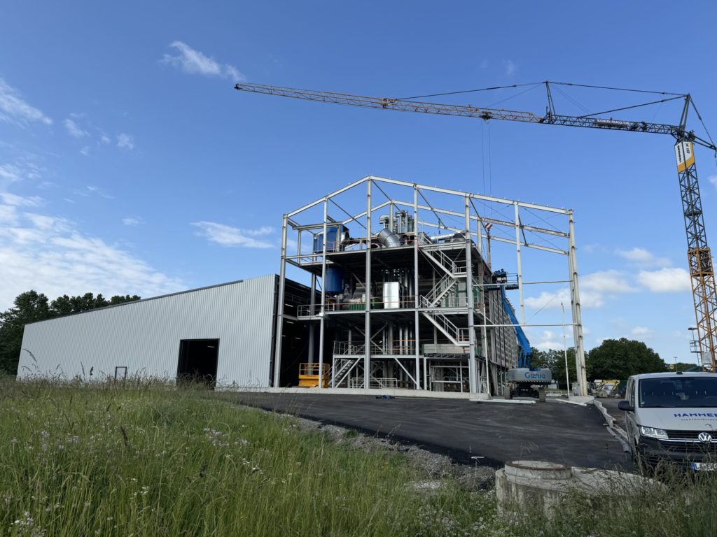 Neubau einer Saatguthalle mit Lager- und Abpackhalle, Baukran im Einsatz vor blauem Himmel.